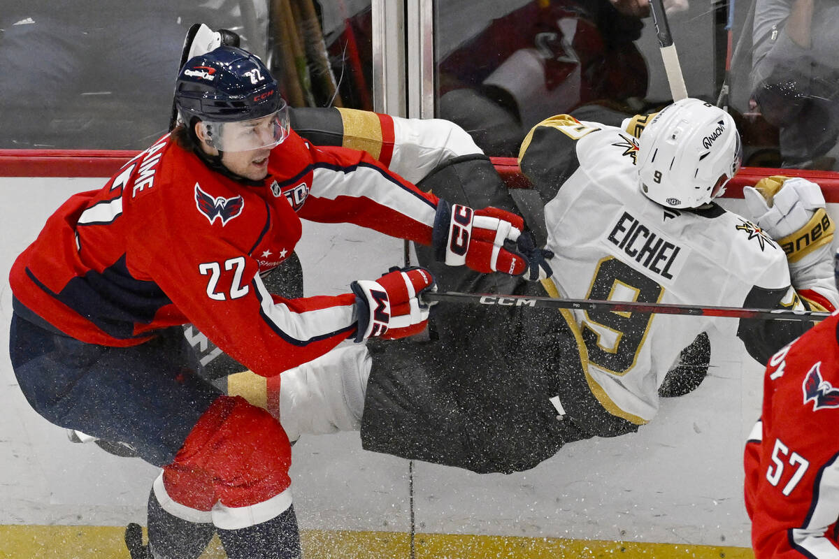 Washington Capitals right wing Brandon Duhaime (22) checks Vegas Golden Knights center Jack Eic ...