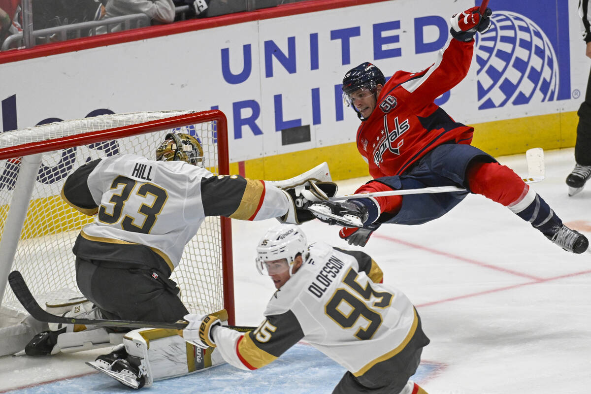 Washington Capitals center Nic Dowd, right, collides with Vegas Golden Knights goaltender Adin ...