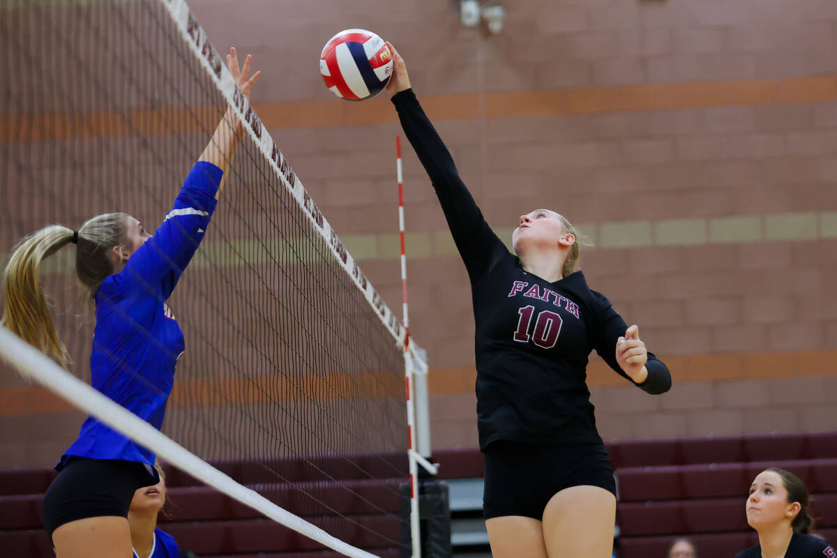 Faith Lutheran middle blocker Abby Keyes (10) spikes the ball during a volleyball game between ...