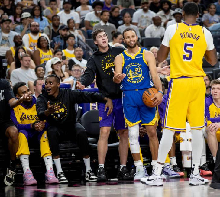 Golden State Warriors guard Stephen Curry (30) and the Los Angeles Lakers bench reacts after Lo ...