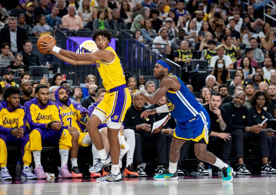 Los Angeles Lakers guard Max Christie (12) keeps the ball from Golden State Warriors guard Budd ...