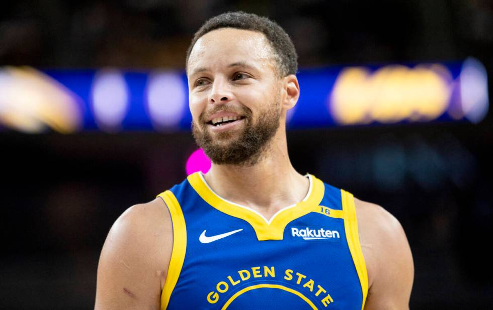 Golden State Warriors guard Stephen Curry smiles during the NBA preseason basketball game again ...