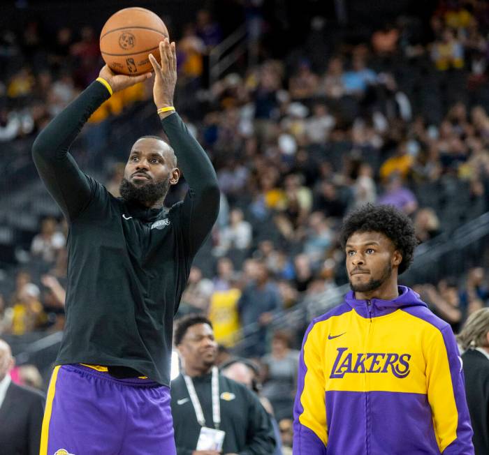 Los Angeles Lakers forward LeBron James, left, and guard Bronny James Jr., right, warm up befor ...