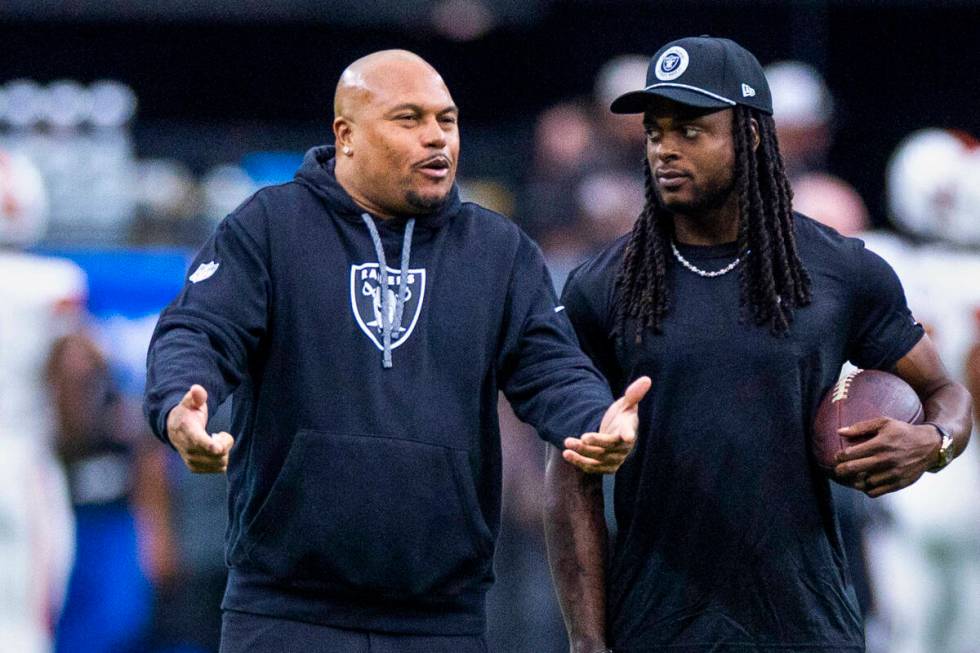 Raiders Head Coach Antonio Pierce chats with wide receiver Davante Adams (17) during the warm u ...