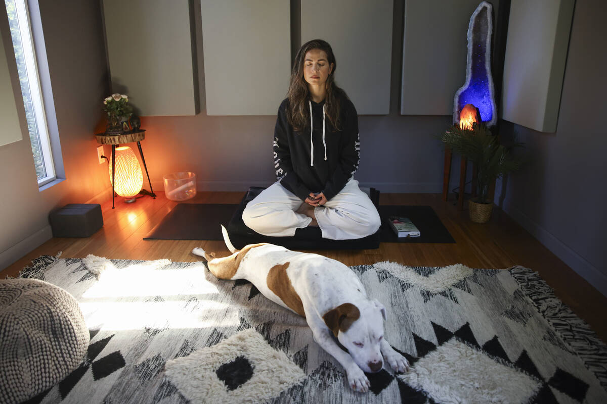 Headspace meditation teacher, Rosie Acosta, meditates in her studio with her dog Monday, Sept. ...