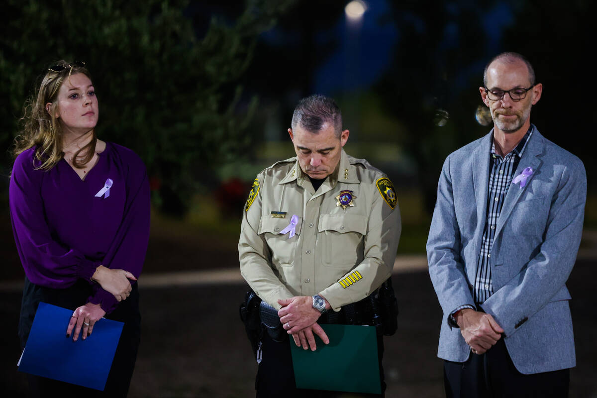 Metro Undersheriff Andrew Walsh, middle, bows his head during a tree dedication ceremony in hon ...