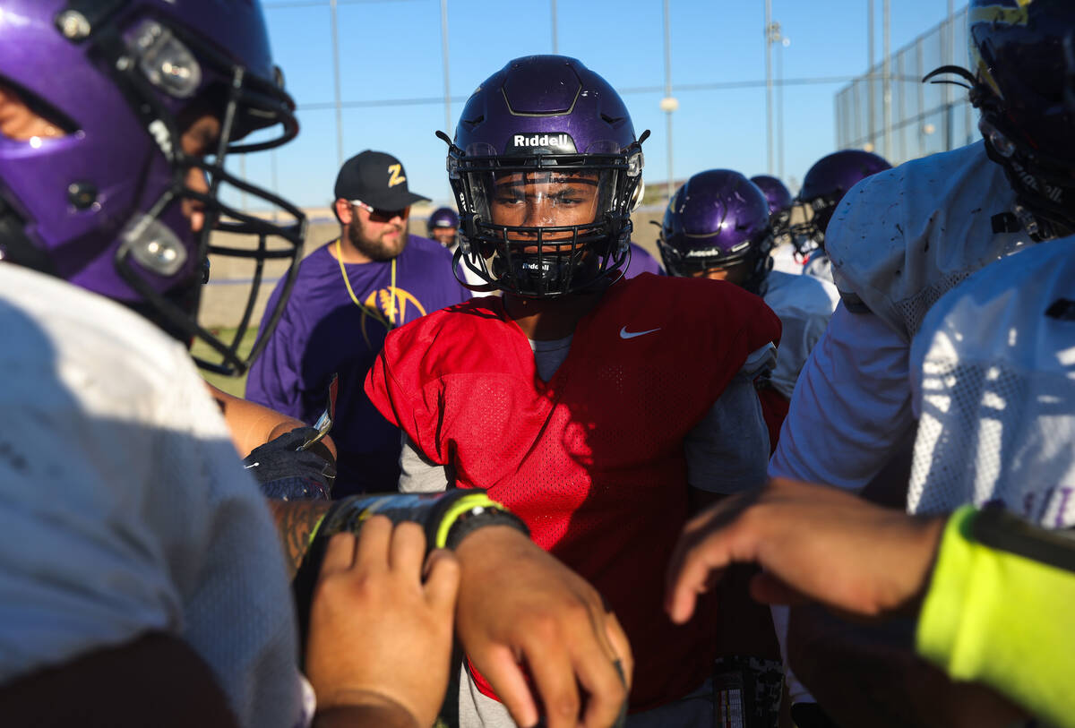 Quarterback Alexander Mercurius speaks with teammates during a huddle at football practice at D ...