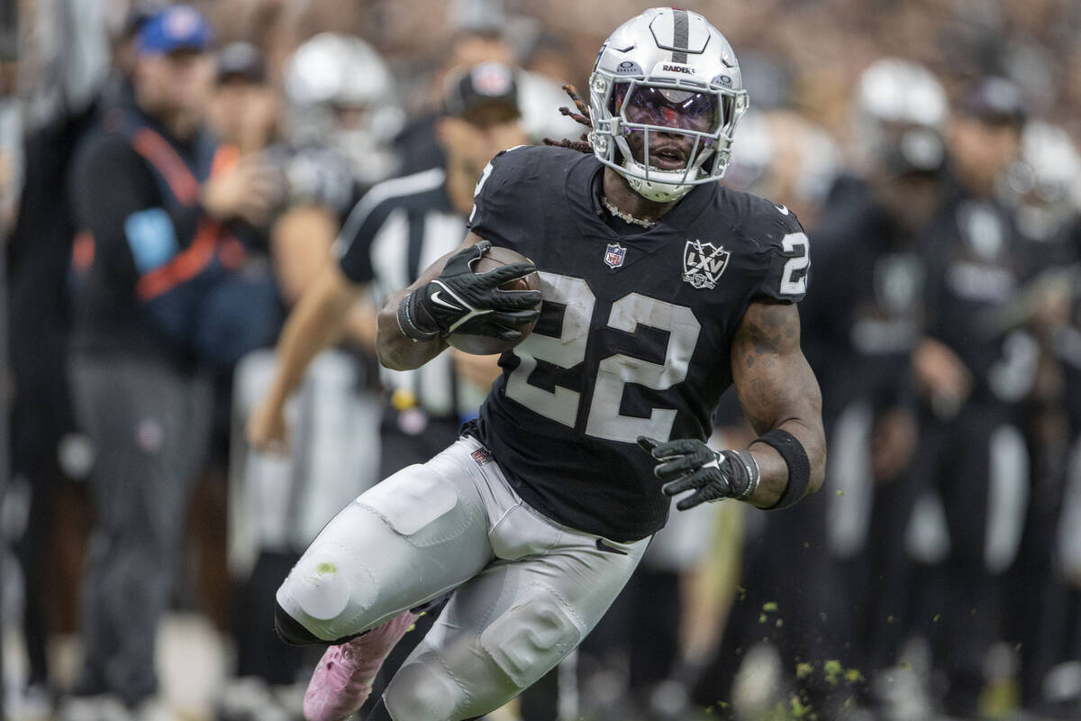 Vegas Raiders running back Alexander Mattison (22) runs with the football during the first half ...