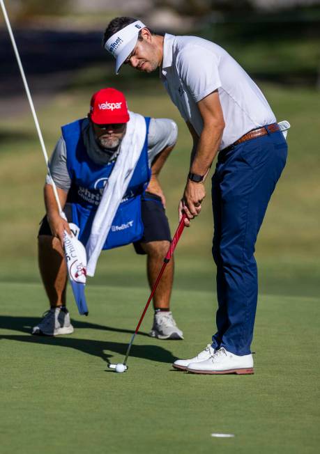 Beau Hossler sets up a putt as his caddie double checks the line at hole #7 during the opening ...