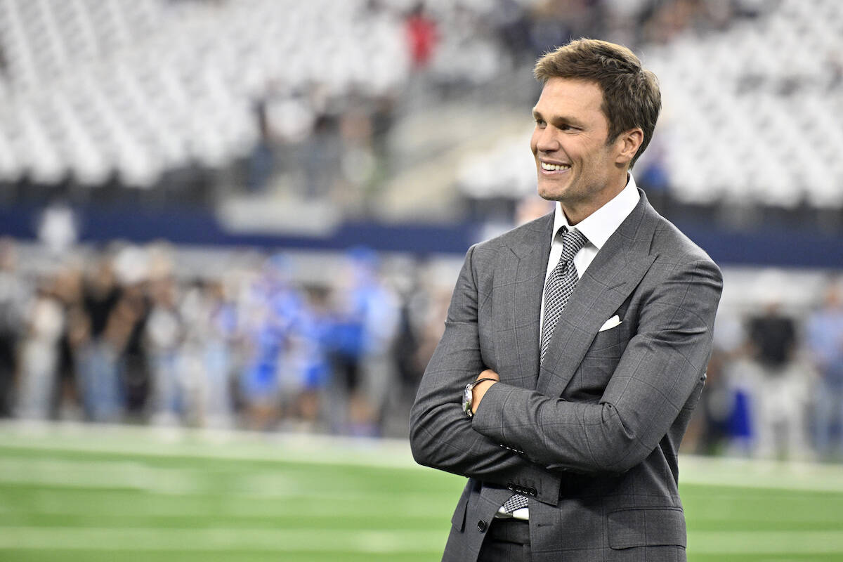 Analyst Tom Brady stands on the field during warmups before first an NFL football game between ...