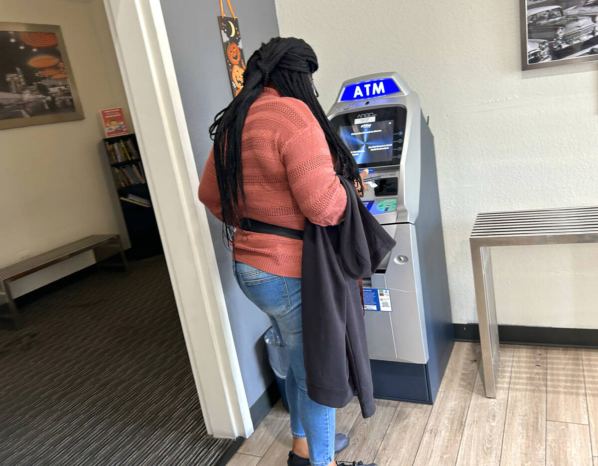 An unidentified customer prepares to use an ATM at the lobby of Siegel Suites on Flamingo Boule ...