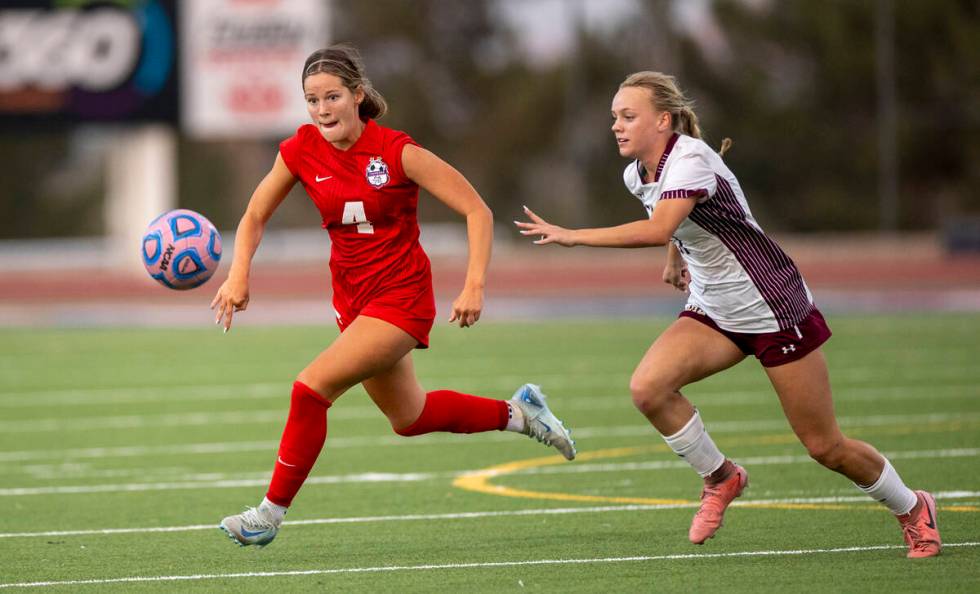 Coronado defender Ella Schultz (4) and Faith Lutheran sophomore Julia Anfinson (17) run after t ...