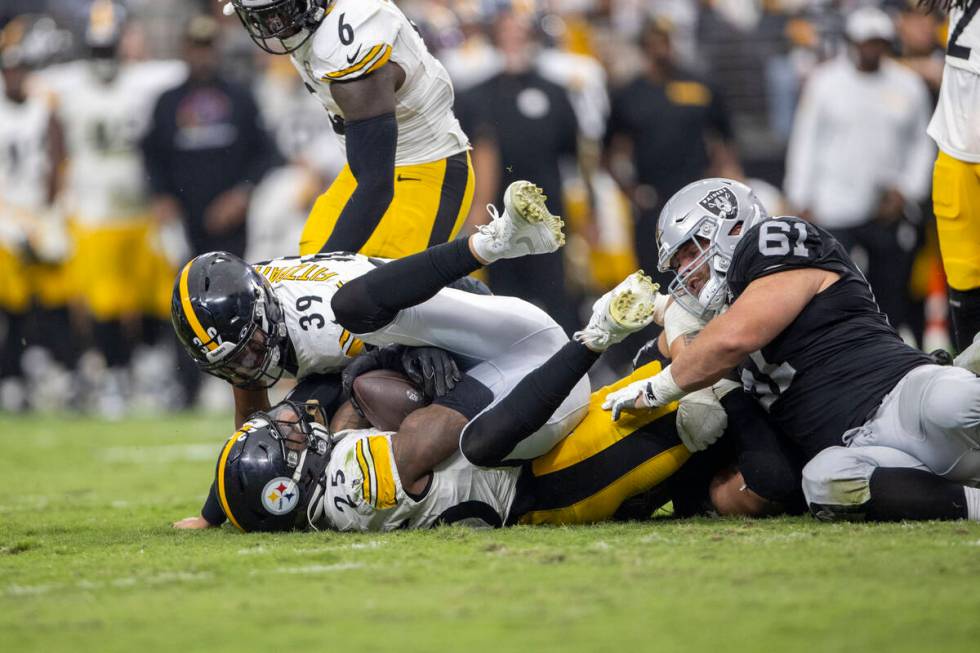 Pittsburgh Steelers safety DeShon Elliott (25) is tackled by Raiders guard Jordan Meredith (61) ...