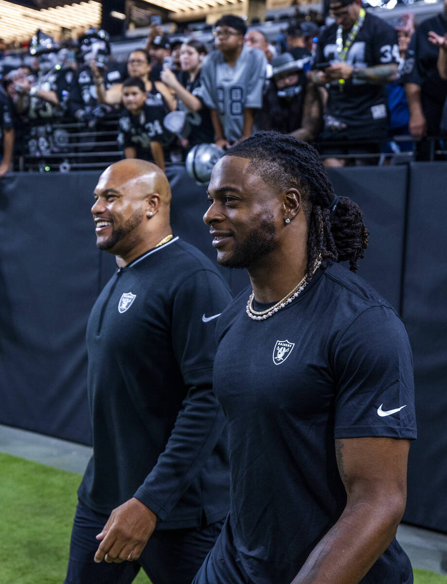 Raiders head coach Antonio Pierce and wide receiver Davante Adams (17) take the field for the f ...