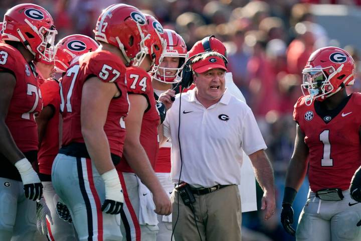 Georgia head coach Kirby Smart talks with his players in the first half of an NCAA college foot ...