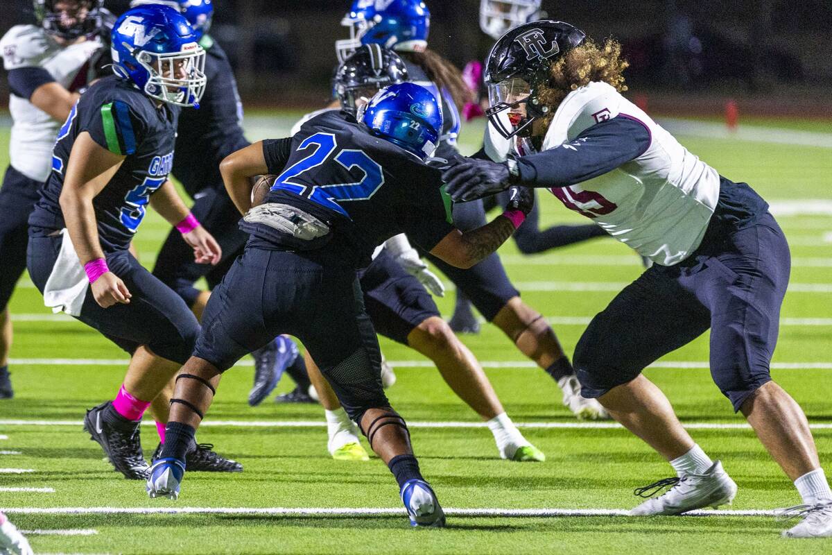 Green Valley running back Cris Dalina (22) is stopped behind the line by Faith Lutheran defensi ...