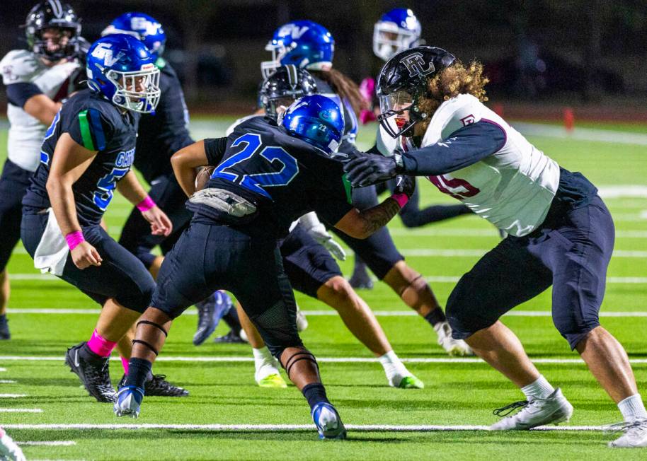 Green Valley running back Chris Dalina (22) is stopped behind the line by Faith Lutheran defens ...