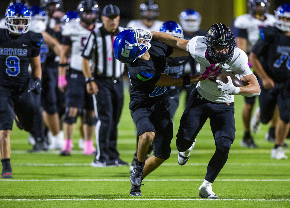 Green Valley free safety Sonny Uranich (27) attempts to stop Faith Lutheran wide receiver Mack ...