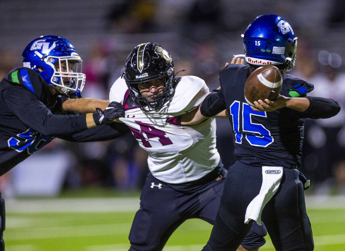 Green Valley quarterback Michael Lewis (15) is stopped on a pass attempt by Faith Lutheran defe ...