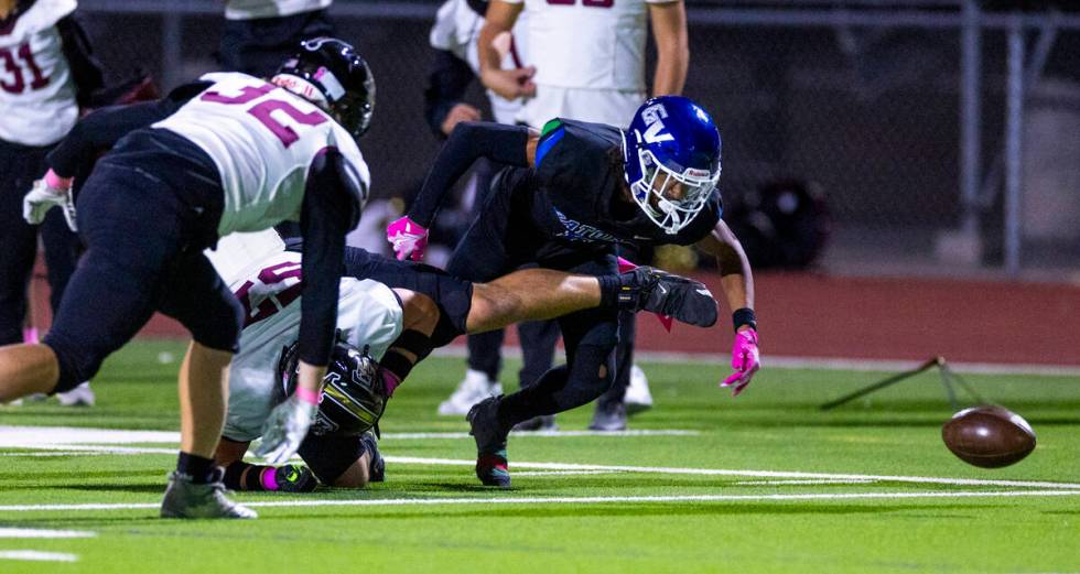 Faith Lutheran offensive lineman Carter Besser (57) hits and dislodges the ball from Green Vall ...