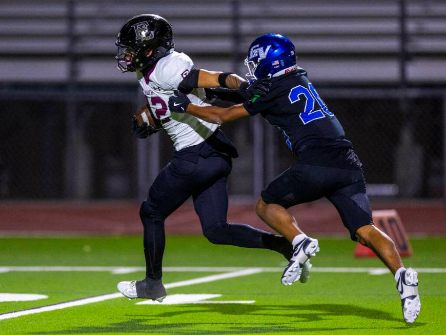 Faith Lutheran wide receiver Aipa Kuloloia (12) pushes off of Green Valley cornerback Jerome Ko ...