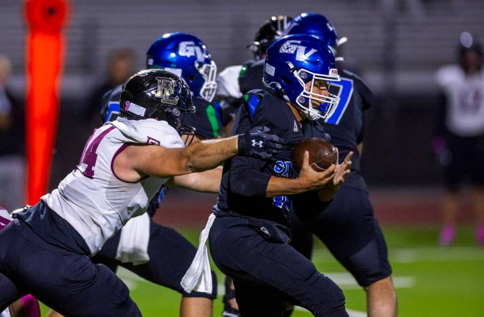 Green Valley quarterback Michael Lewis (15) is stopped again by Faith Lutheran defensive linema ...