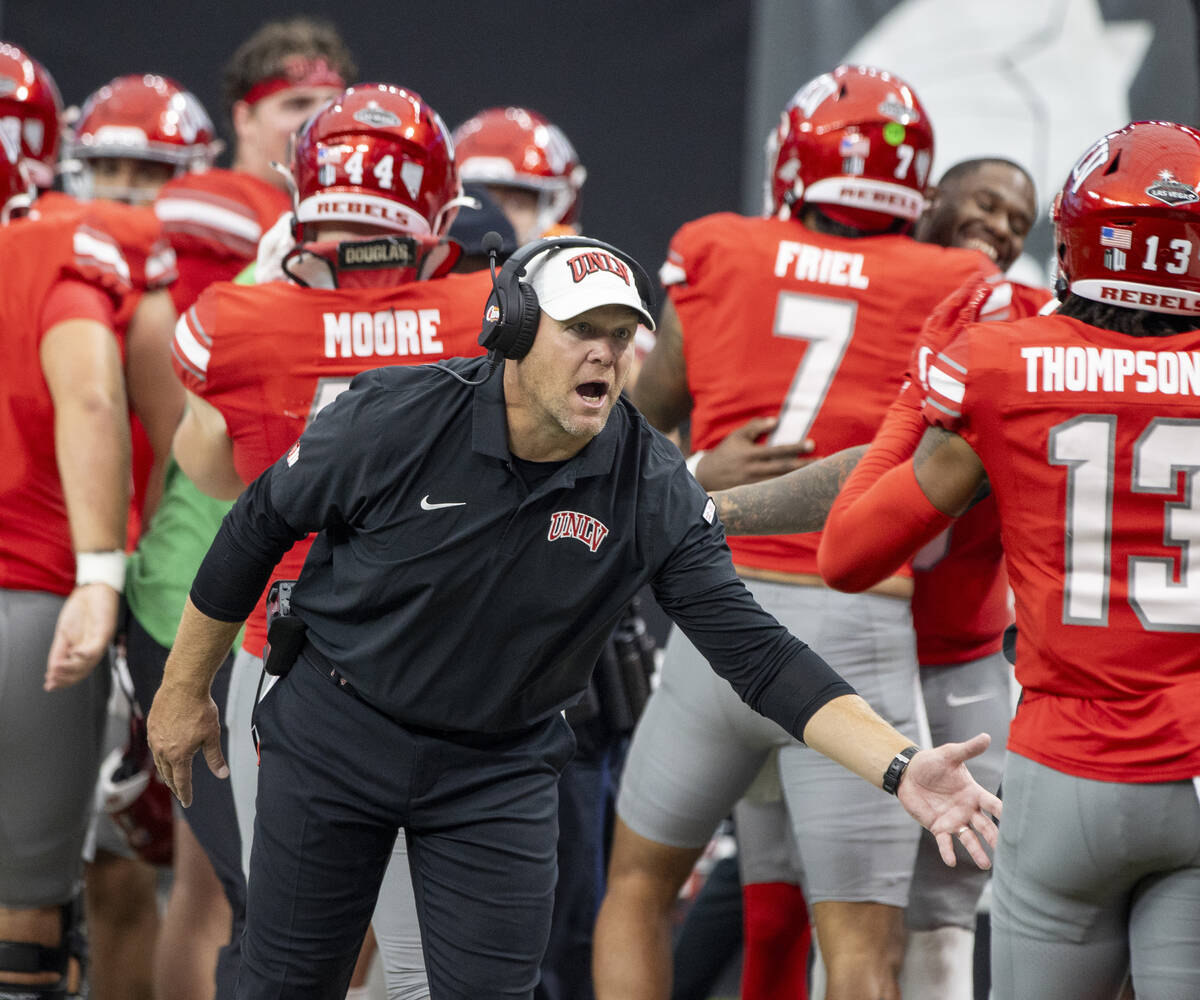 UNLV head coach Barry Odom welcomes players back to the sideline after scoring a touchdown duri ...