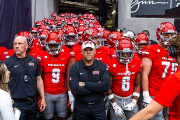 UNLV Head Coach Barry Odom and players await introduction as the ready to face the Fresno State ...