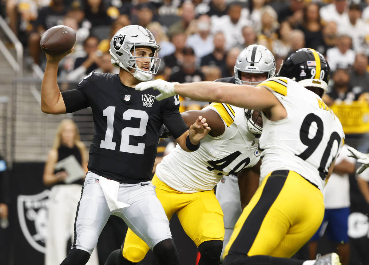 Raiders quarterback Aidan O'Connell (12) throws under pressure from Pittsburgh Steelers linebac ...