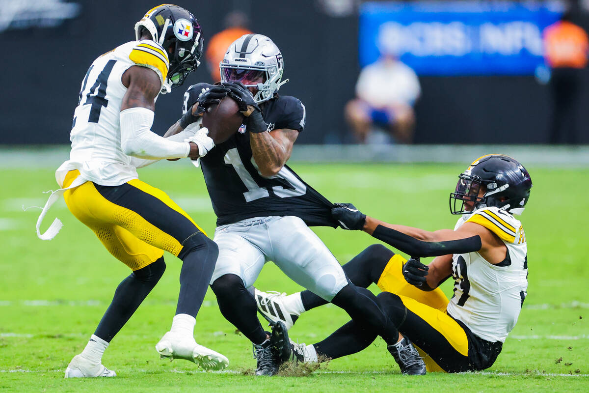 Raiders wide receiver DJ Turner (19) gets pulled down as he carries the ball by Pittsburgh Stee ...