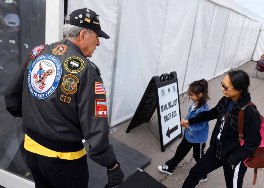 U.S. Air Force Korean War veteran Lee Mowery, 92, greets voters as they arrive to cast their vo ...