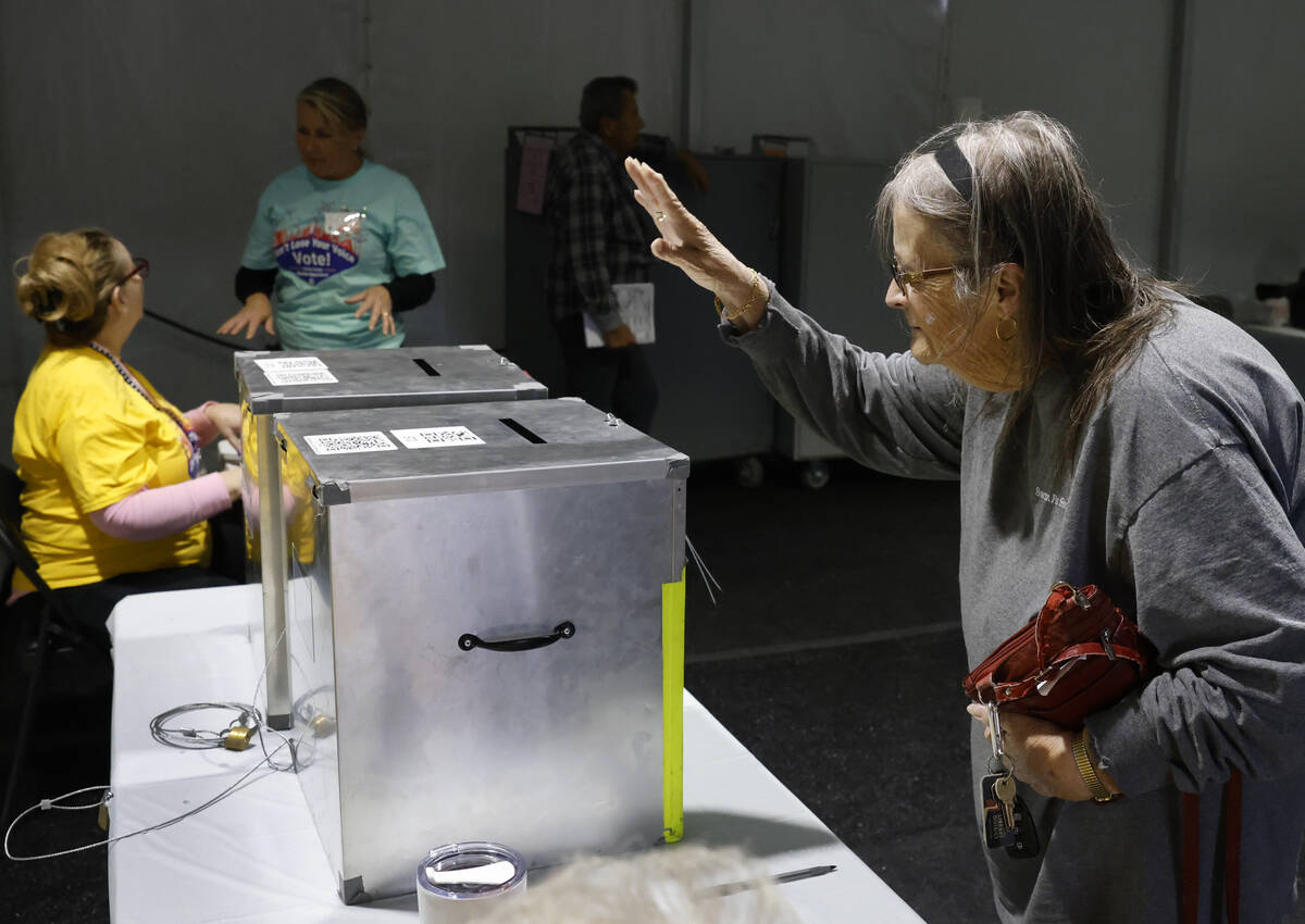 Jean Debarre reacts after dropping her ballots in an official mail-in ballot drop box during ea ...