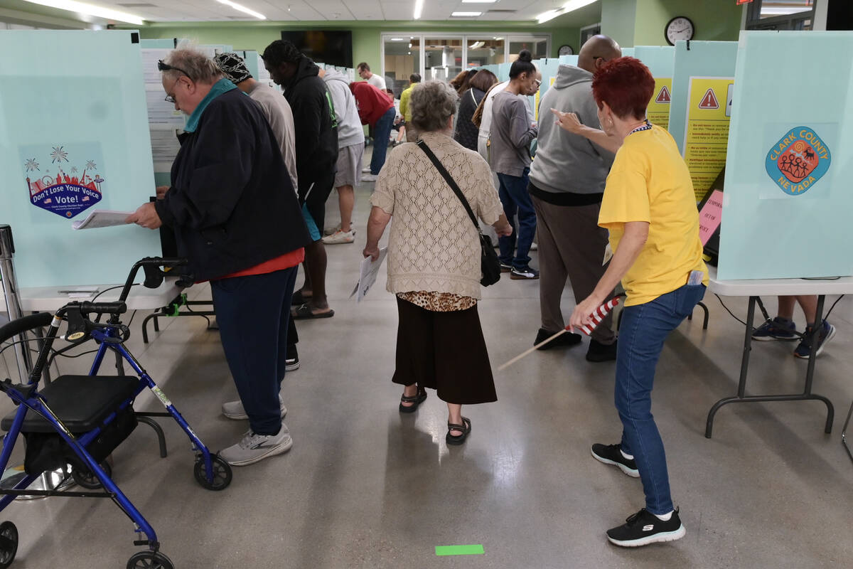 A voter is directed to an available voting booth at the Silverado Ranch Community Center Saturd ...