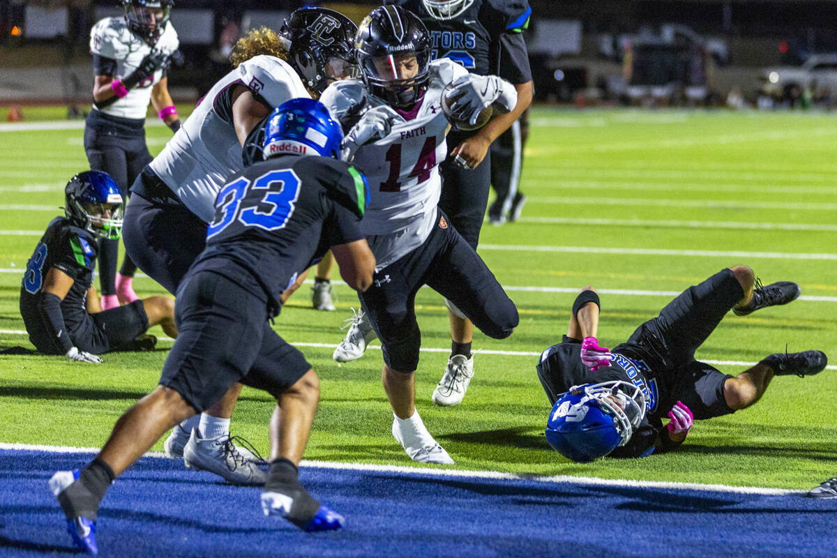 Faith Lutheran running back Cale Breslin (14) scores as Green Valley defensive end Nash Wilkins ...