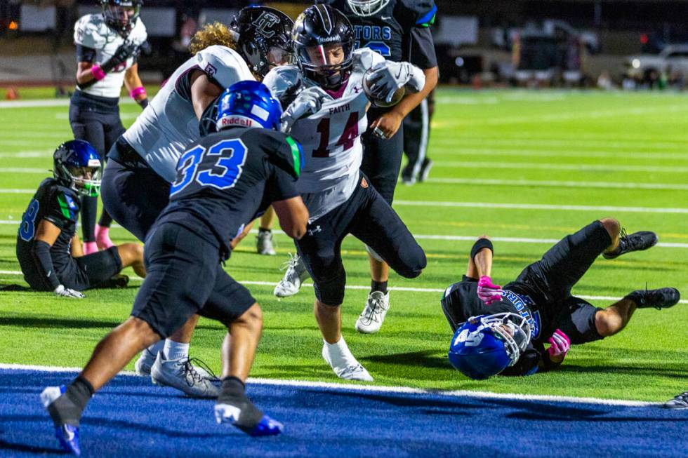 Faith Lutheran running back Cale Breslin (14) scores as Green Valley defensive end Nash Wilkins ...