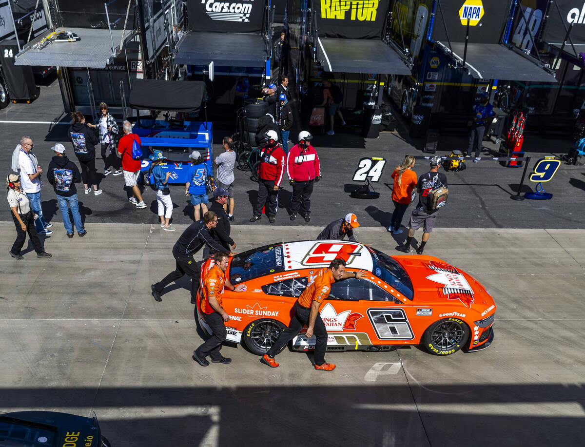 Crew members wheel Brad Keselowski's car past the Neon Garage before NASCAR Cup Series practice ...