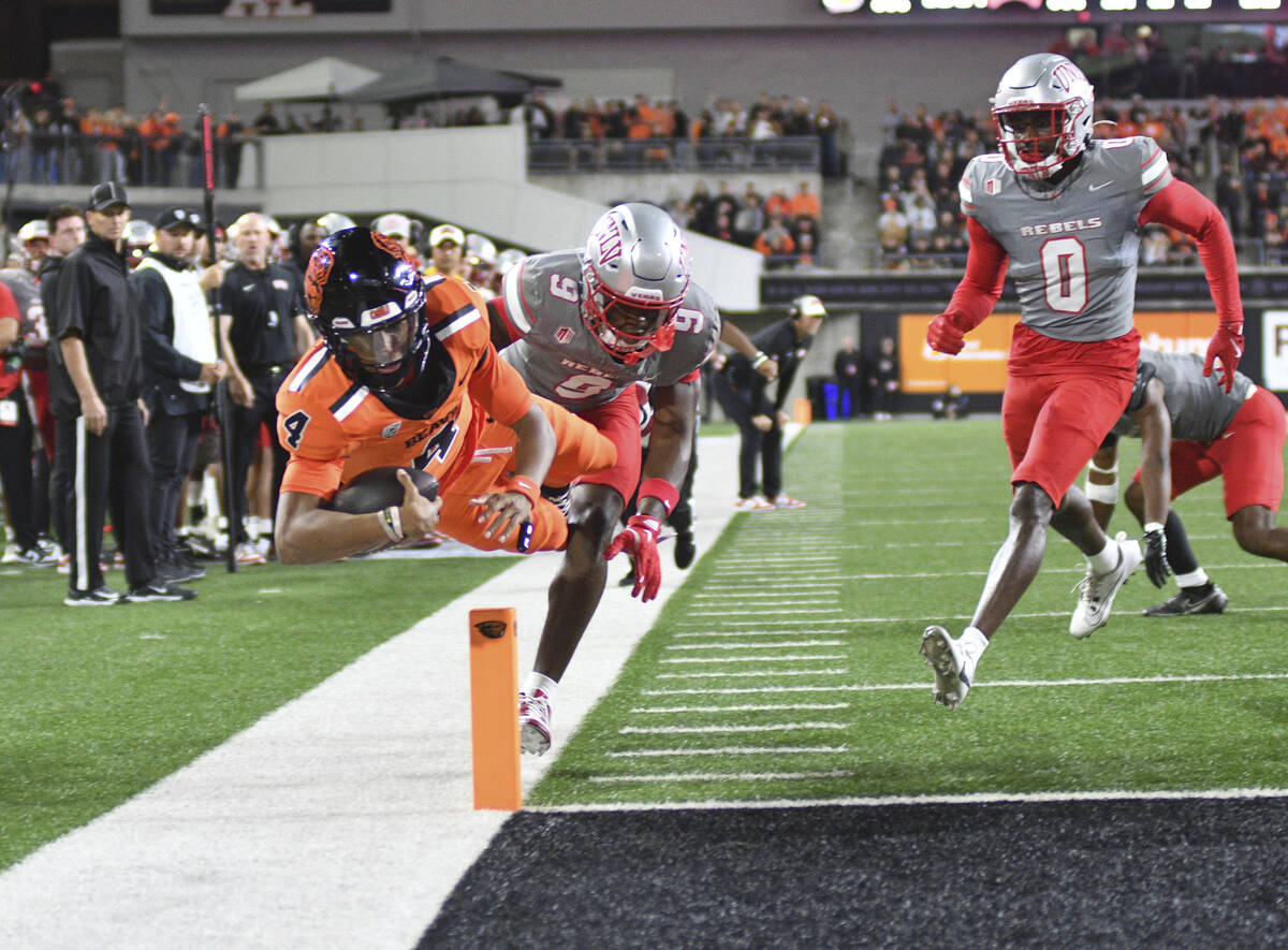 UNLV defensive back Jett Elad (9) pushes Oregon State quarterback Gevani McCoy (4) out of bound ...