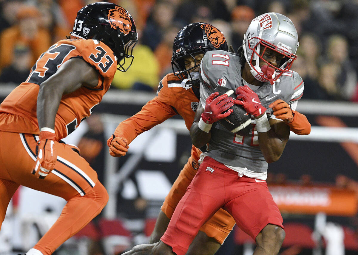 UNLV wide receiver Ricky White III (11) catches a pass in front of Oregon State defensive back ...