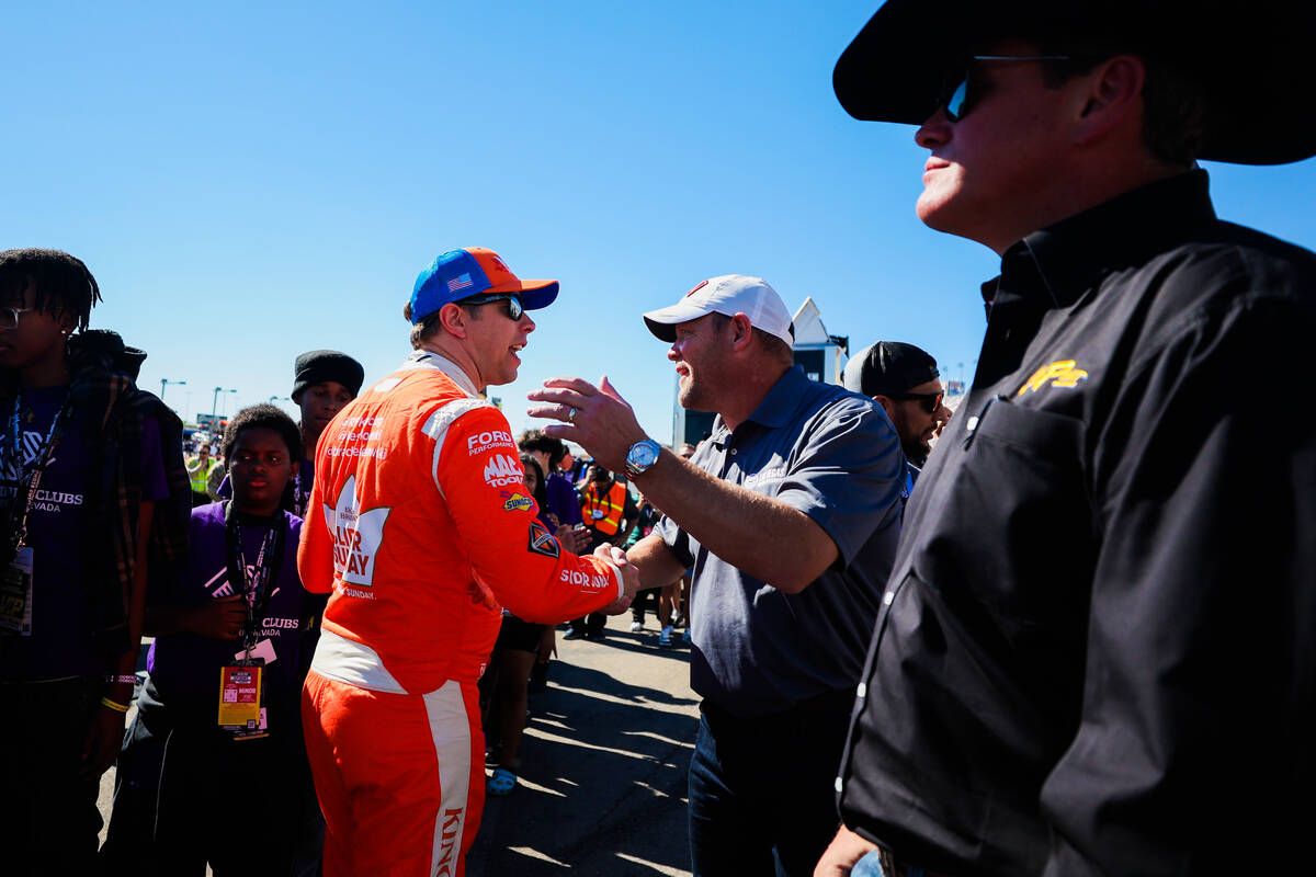 UNLV head football coach Barry Odom shakes hands with race car driver Brad Keselowski during th ...