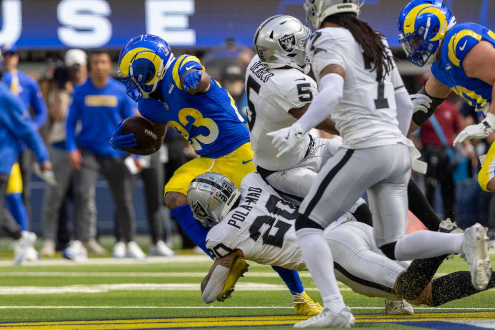 Raiders safety Isaiah Pola-Mao (20) tackles Los Angeles Rams running back Kyren Williams (23) d ...