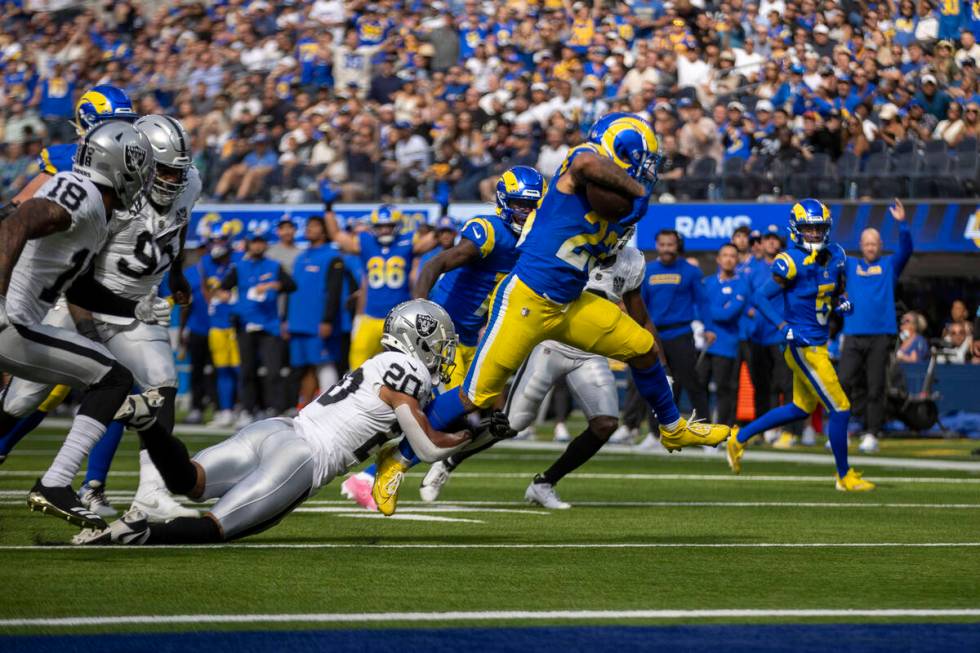 Los Angeles Rams running back Kyren Williams (23) escapes a tackle by Raiders safety Isaiah Pol ...