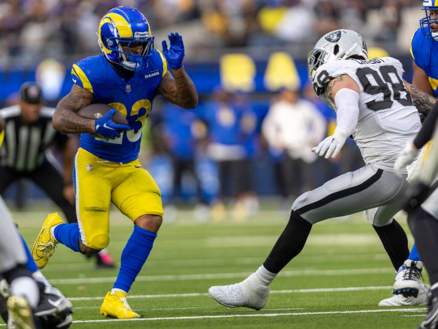 Los Angeles Rams running back Kyren Williams (23) rushes past Raiders defensive end Maxx Crosby ...