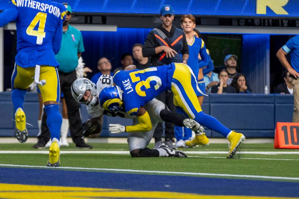 Los Angeles Rams safety Quentin Lake (37) tackles Raiders tight end Brock Bowers (89) short of ...