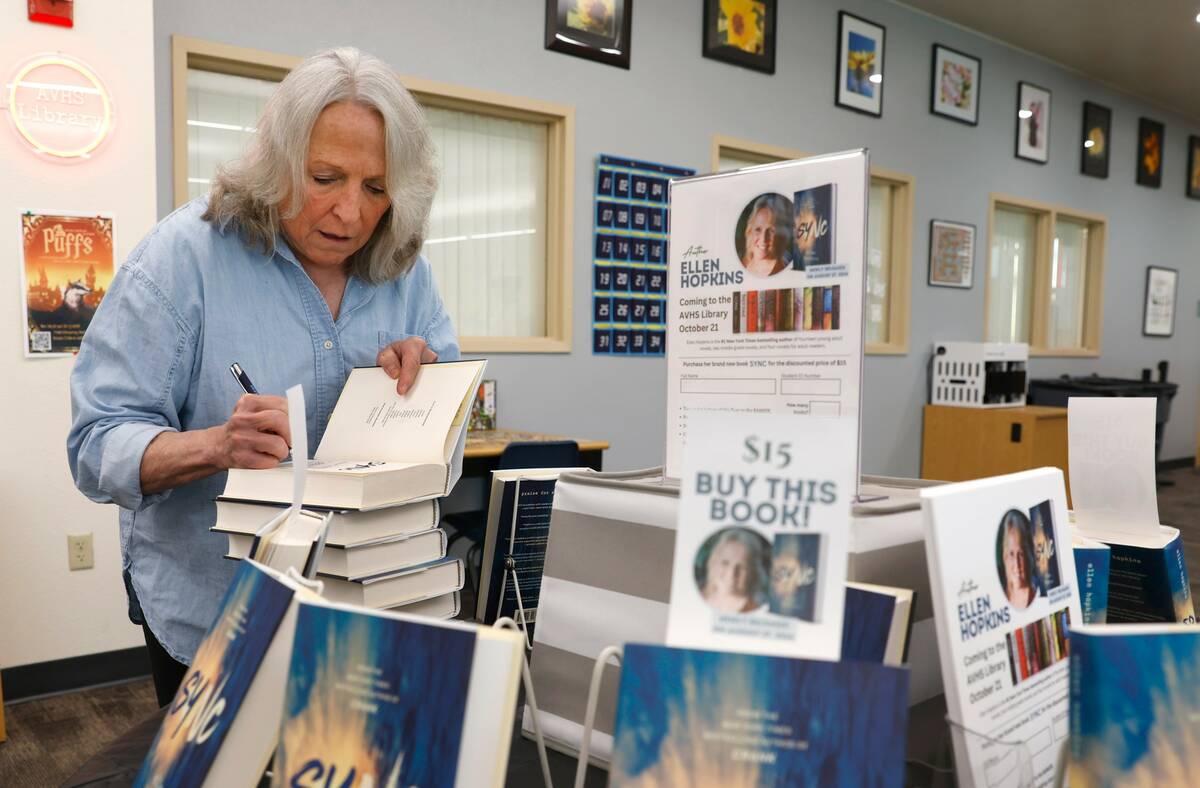 Ellen Hopkins, a banned author, signs her book titled "Sync" after speaking to students at Arbo ...