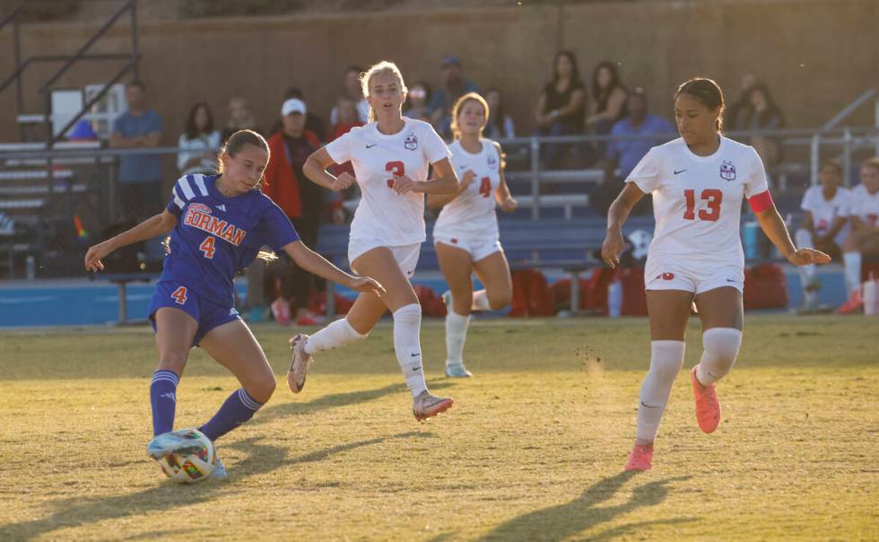 Bishop Gorman midfielder Gianna Tomasello (4) kicks the ball under pressure from Coronado midfi ...