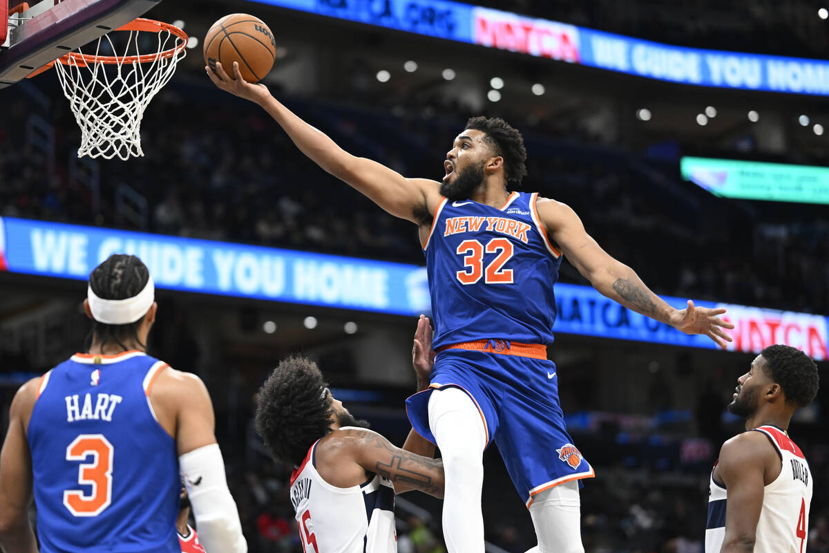 New York Knicks center Karl-Anthony Towns (32) scores over Washington Wizards forward Marvin Ba ...