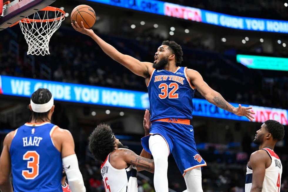 New York Knicks center Karl-Anthony Towns (32) scores over Washington Wizards forward Marvin Ba ...