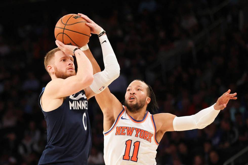 Minnesota Timberwolves guard Donte DiVincenzo, left, is defended by New York Knicks guard Jalen ...