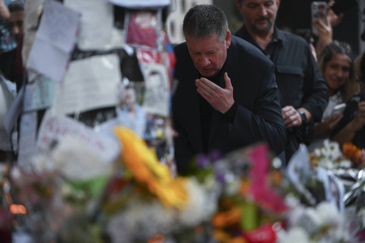 Geoff Payne, right, father of former One Direction member Liam Payne, visits a makeshift altar ...