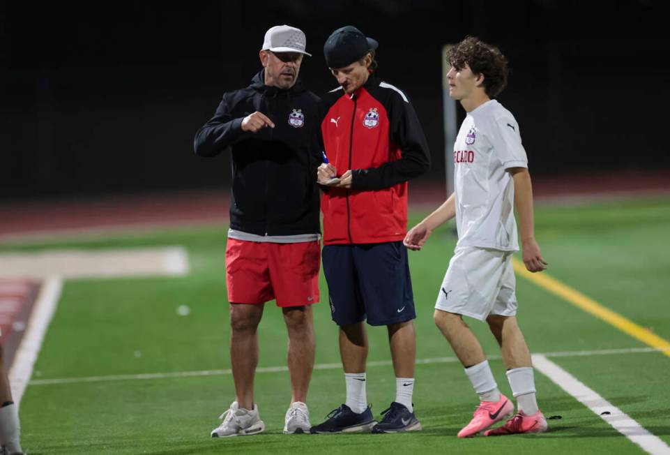 Coronado head coach Dustin Barton, center, takes notes during a break in a soccer game at Palo ...